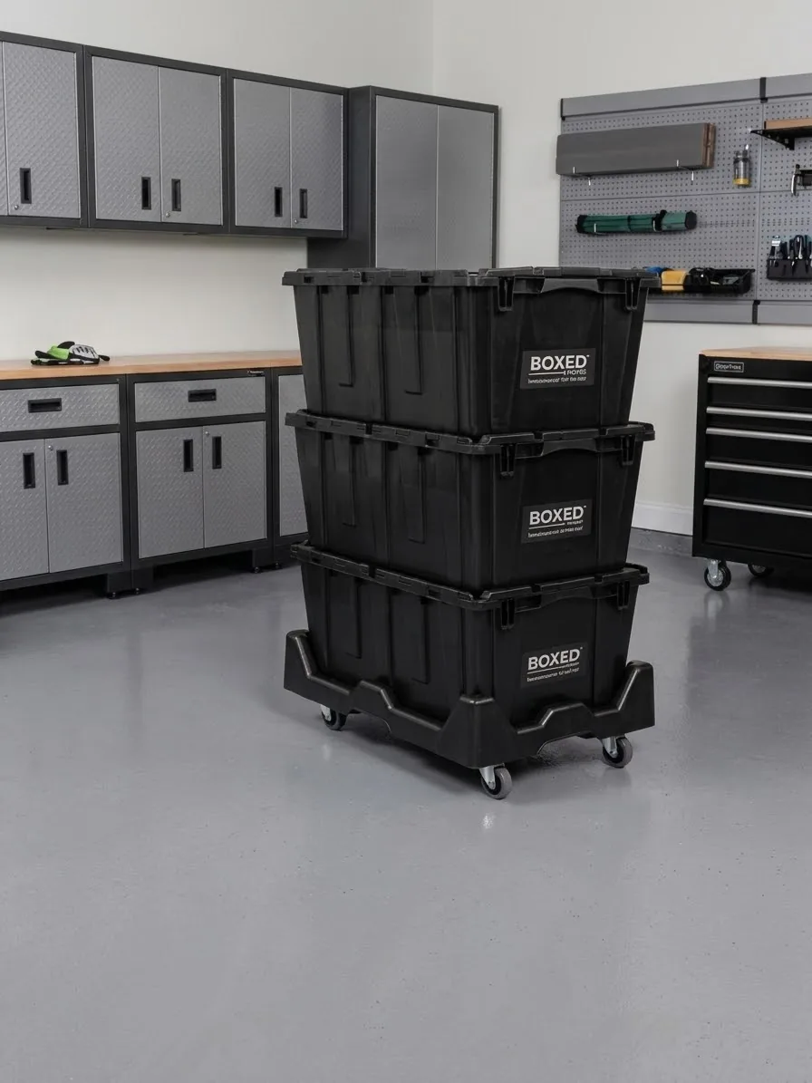 Three Boxed Moves plastic moving boxes stacked on a rolling dolly in an organized garage